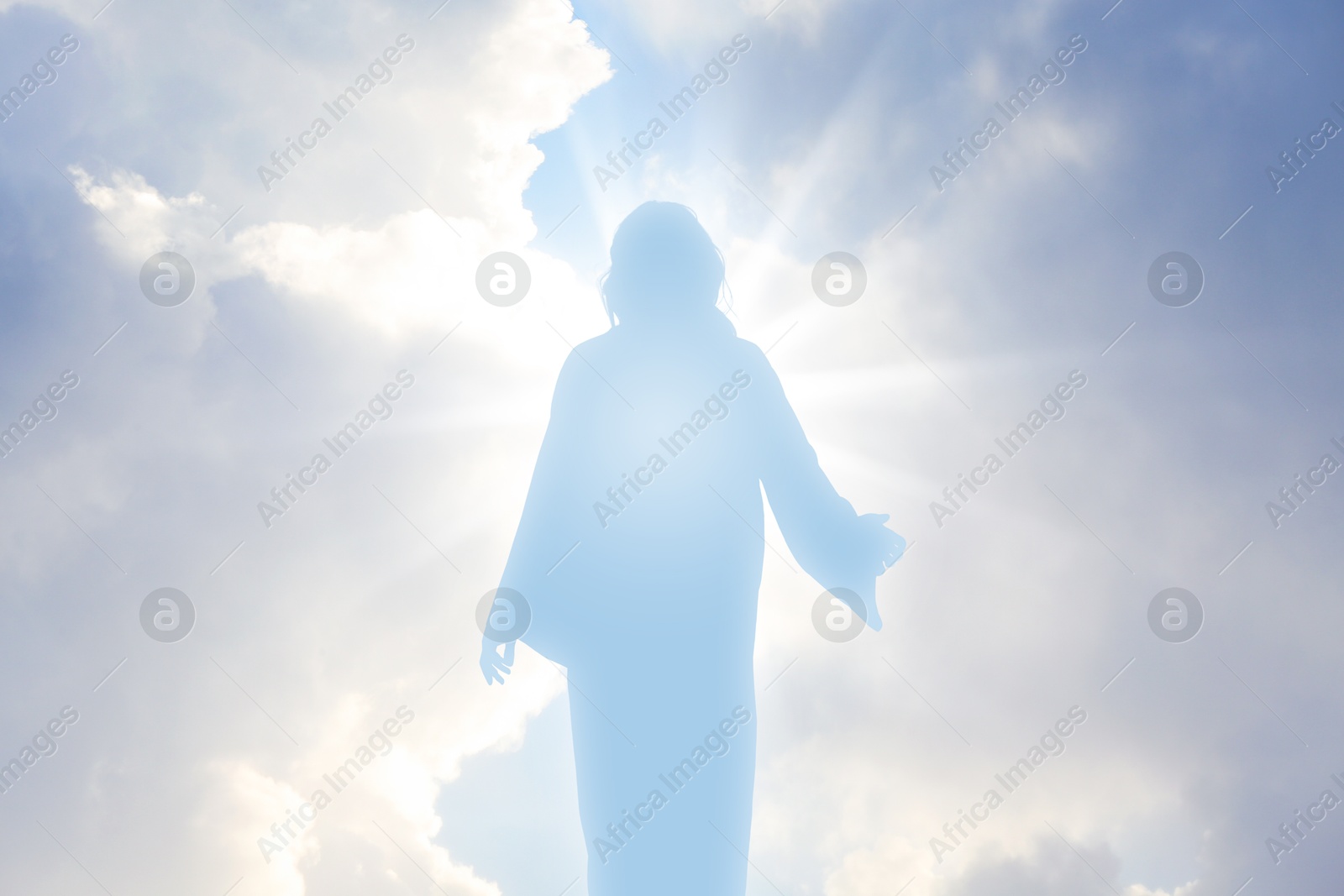 Image of Silhouette of Jesus Christ in sunlight among clouds in sky