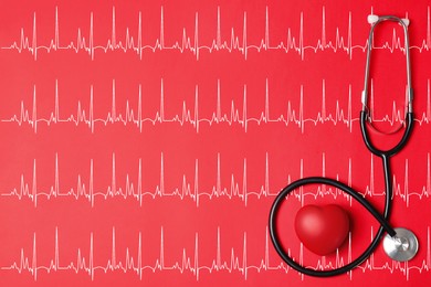 Image of Decorative heart, stethoscope and electrocardiogram on red background, top view