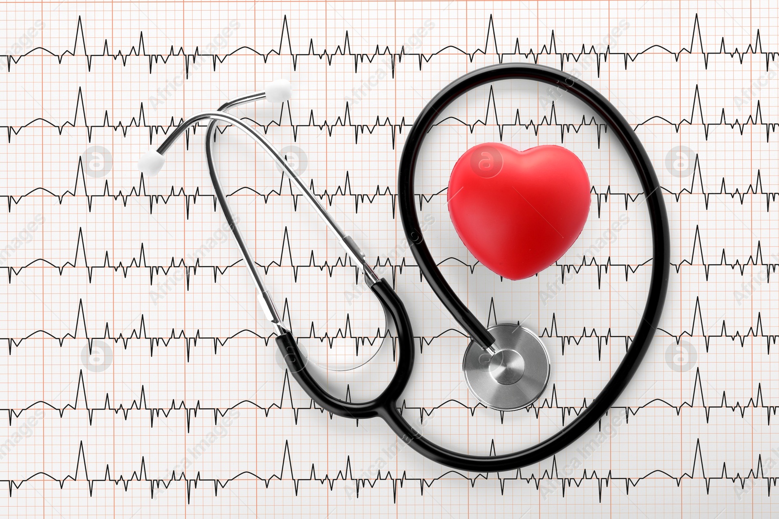 Image of Red decorative heart, stethoscope on electrocardiogram printout, top view