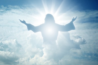 Image of Silhouette of Jesus Christ in sunlight among clouds in sky