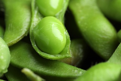 Photo of Fresh edamame pods with soybeans as background, closeup