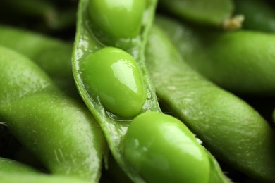 Photo of Fresh edamame pods with soybeans as background, closeup