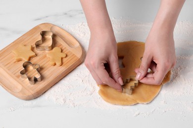 Photo of Woman making cookies with cutters at white marble table, closeup