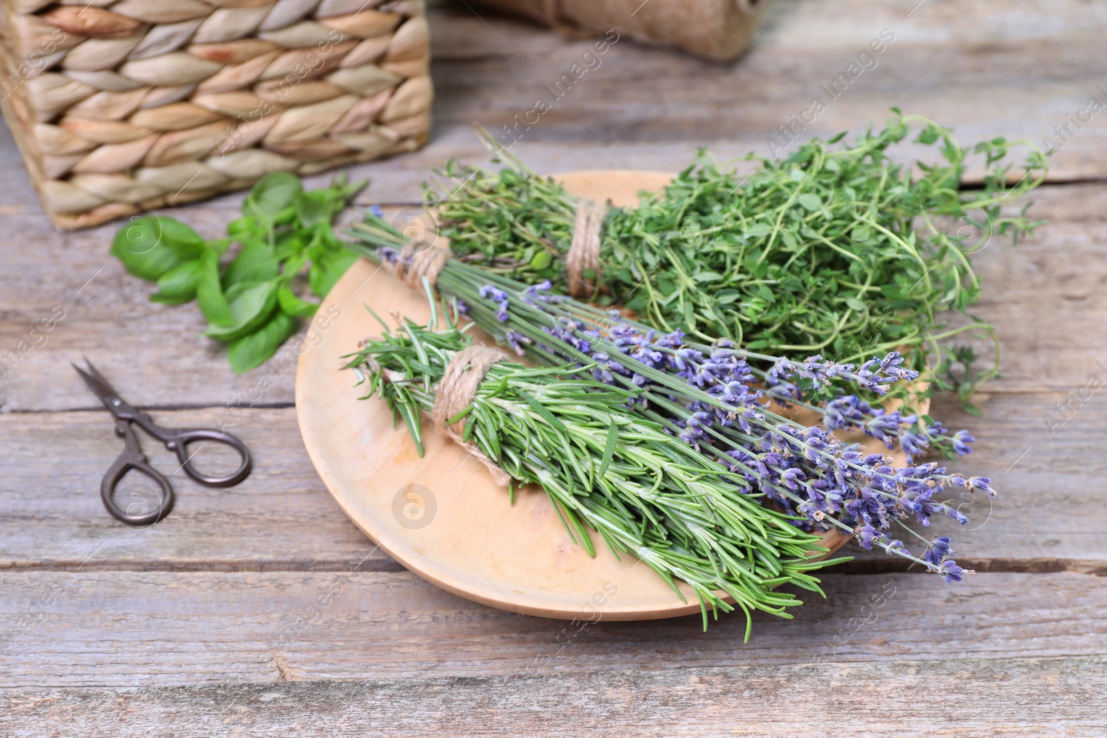 Photo of Different aromatic herbs and scissors on wooden table