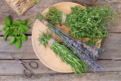 Photo of Different aromatic herbs and scissors on wooden table, flat lay