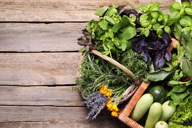 Photo of Different aromatic herbs and vegetables on wooden table, top view. Space for text