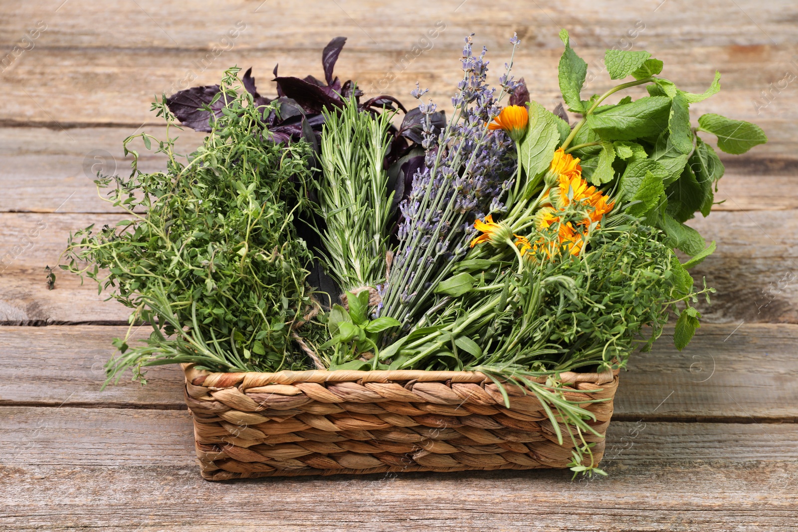 Photo of Different aromatic herbs in basket on wooden table