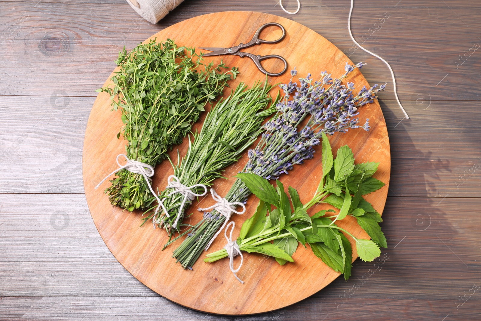 Photo of Different aromatic herbs and scissors on wooden table, top view