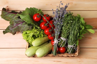 Photo of Different aromatic herbs and vegetables on wooden table, top view