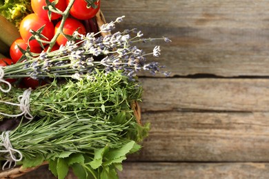 Different aromatic herbs and vegetables on wooden table, top view. Space for text