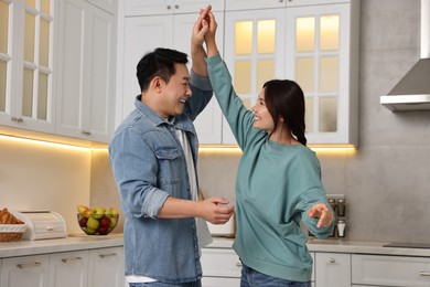 Happy lovely couple dancing together in kitchen