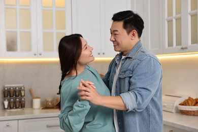 Happy lovely couple dancing together in kitchen