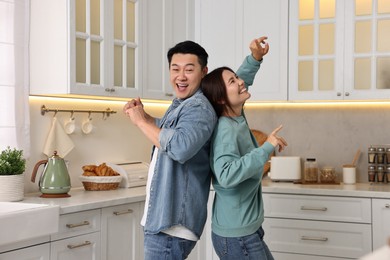 Happy lovely couple dancing together in kitchen