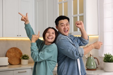 Happy lovely couple dancing together in kitchen