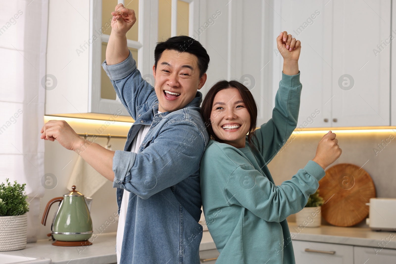 Photo of Happy lovely couple dancing together in kitchen