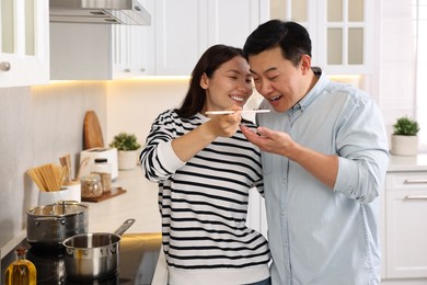 Photo of Happy lovely couple cooking together in kitchen