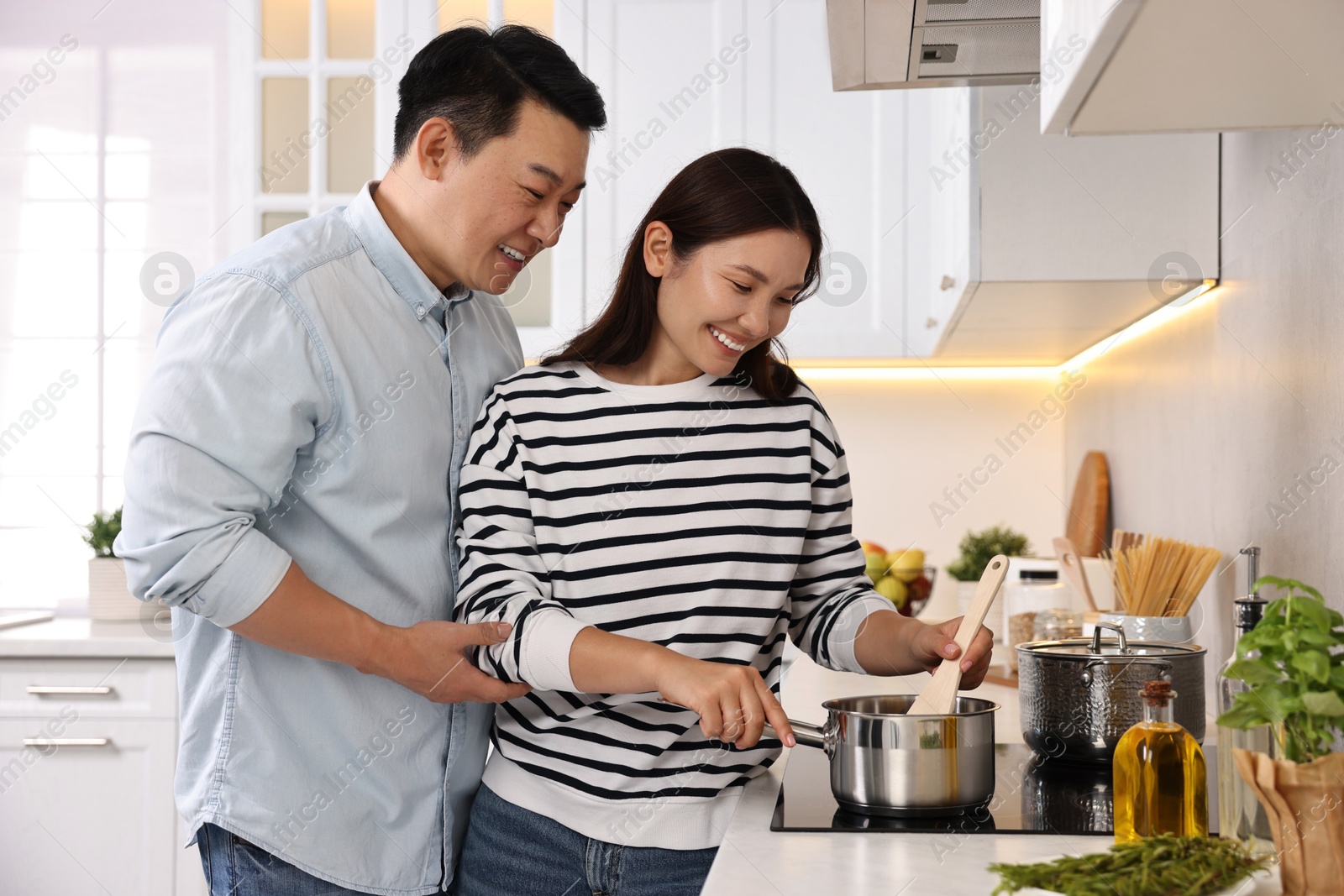 Photo of Happy lovely couple cooking together in kitchen