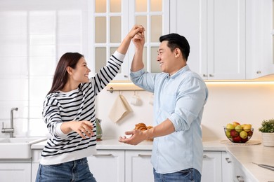 Happy lovely couple dancing together in kitchen