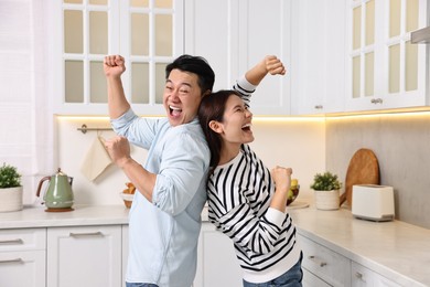 Photo of Happy lovely couple dancing together in kitchen