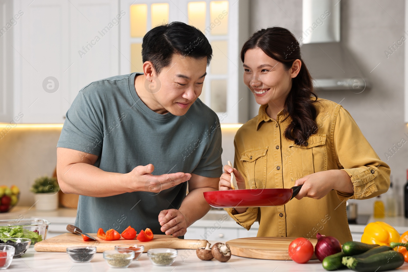 Photo of Happy lovely couple cooking together in kitchen