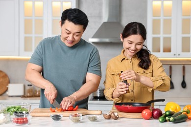 Photo of Happy lovely couple cooking together in kitchen