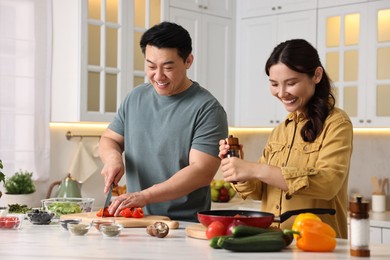 Photo of Happy lovely couple cooking together in kitchen