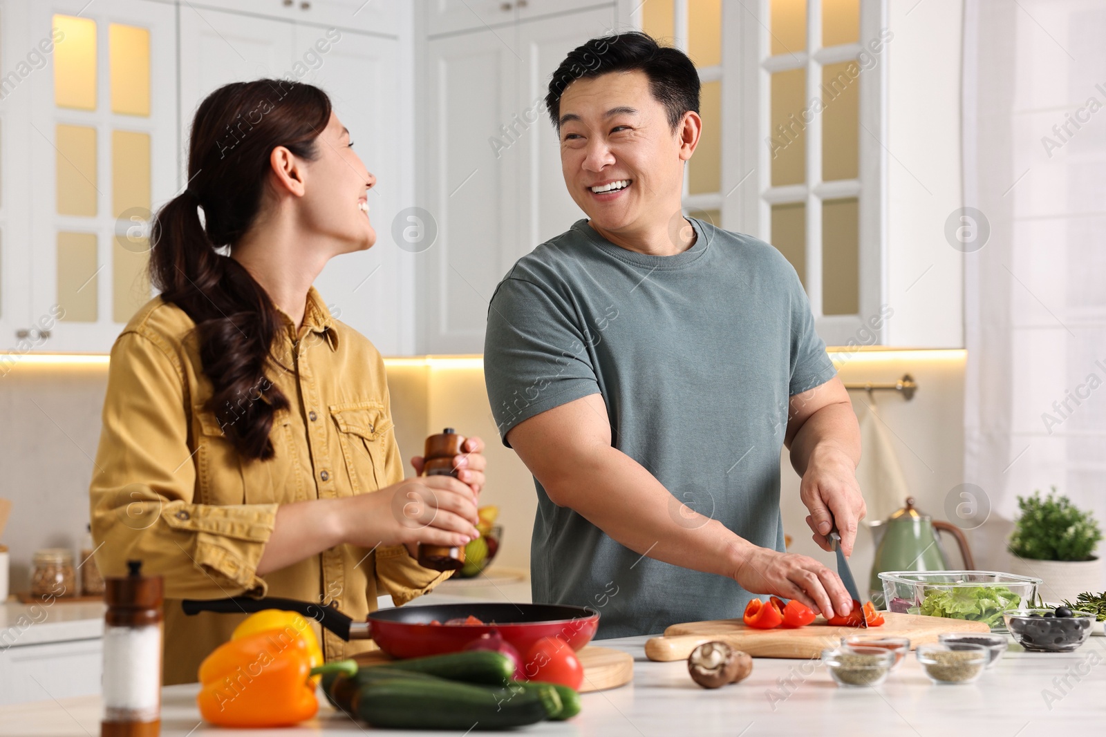 Photo of Happy lovely couple cooking together in kitchen