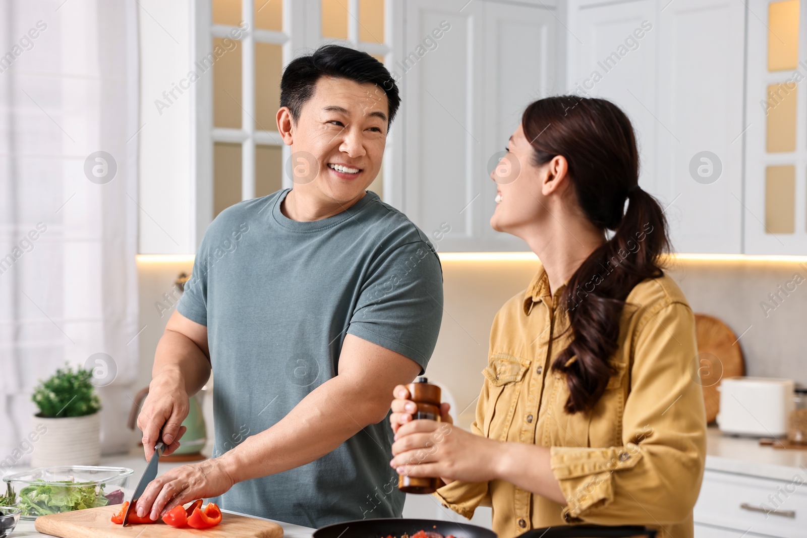 Photo of Happy lovely couple cooking together in kitchen