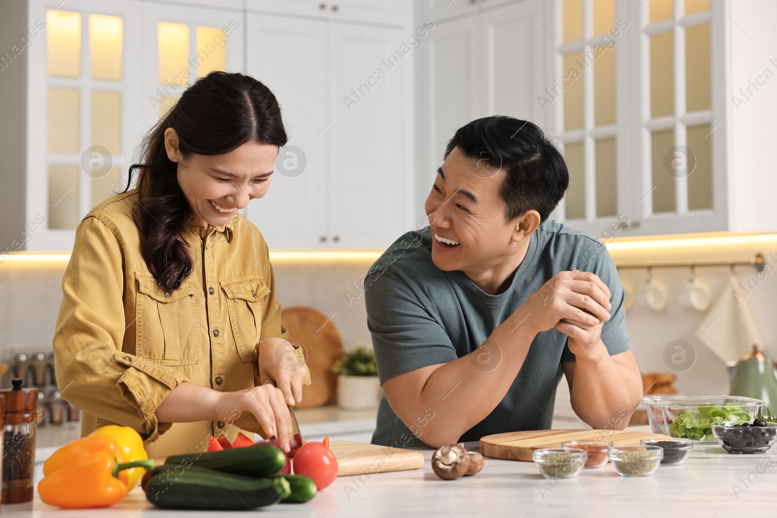 Photo of Happy lovely couple cooking together in kitchen