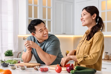 Photo of Happy lovely couple cooking together in kitchen