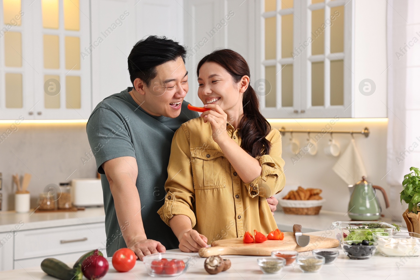 Photo of Happy lovely couple cooking together in kitchen