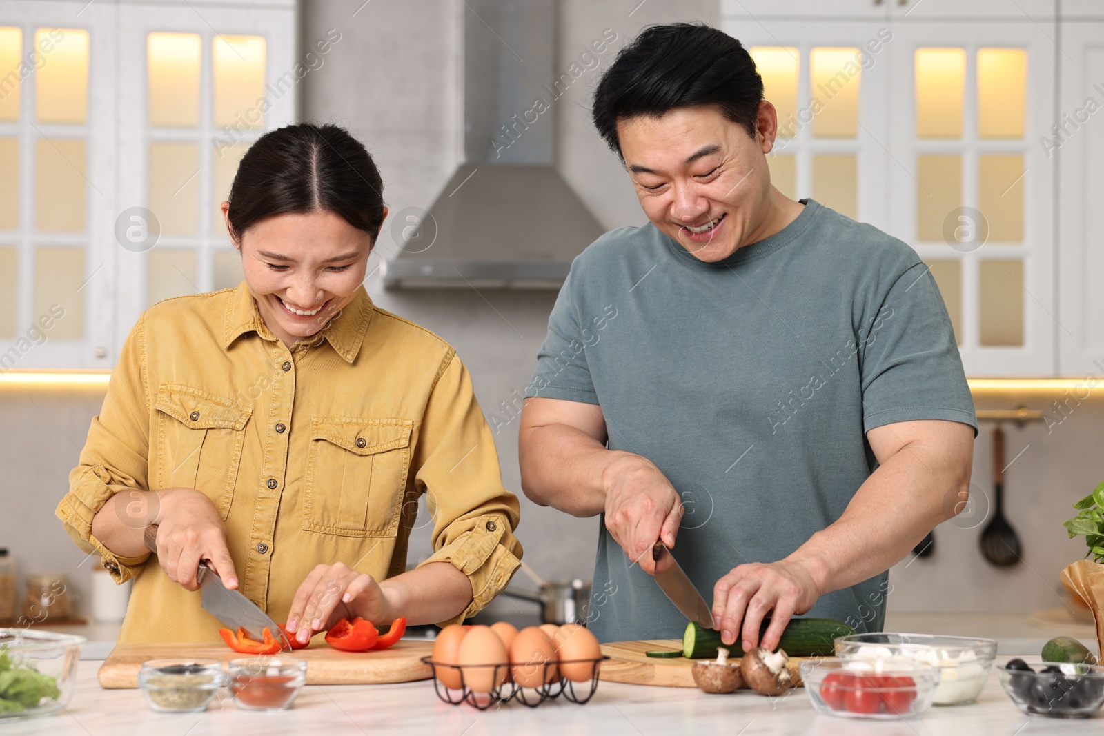 Photo of Happy lovely couple cooking together in kitchen