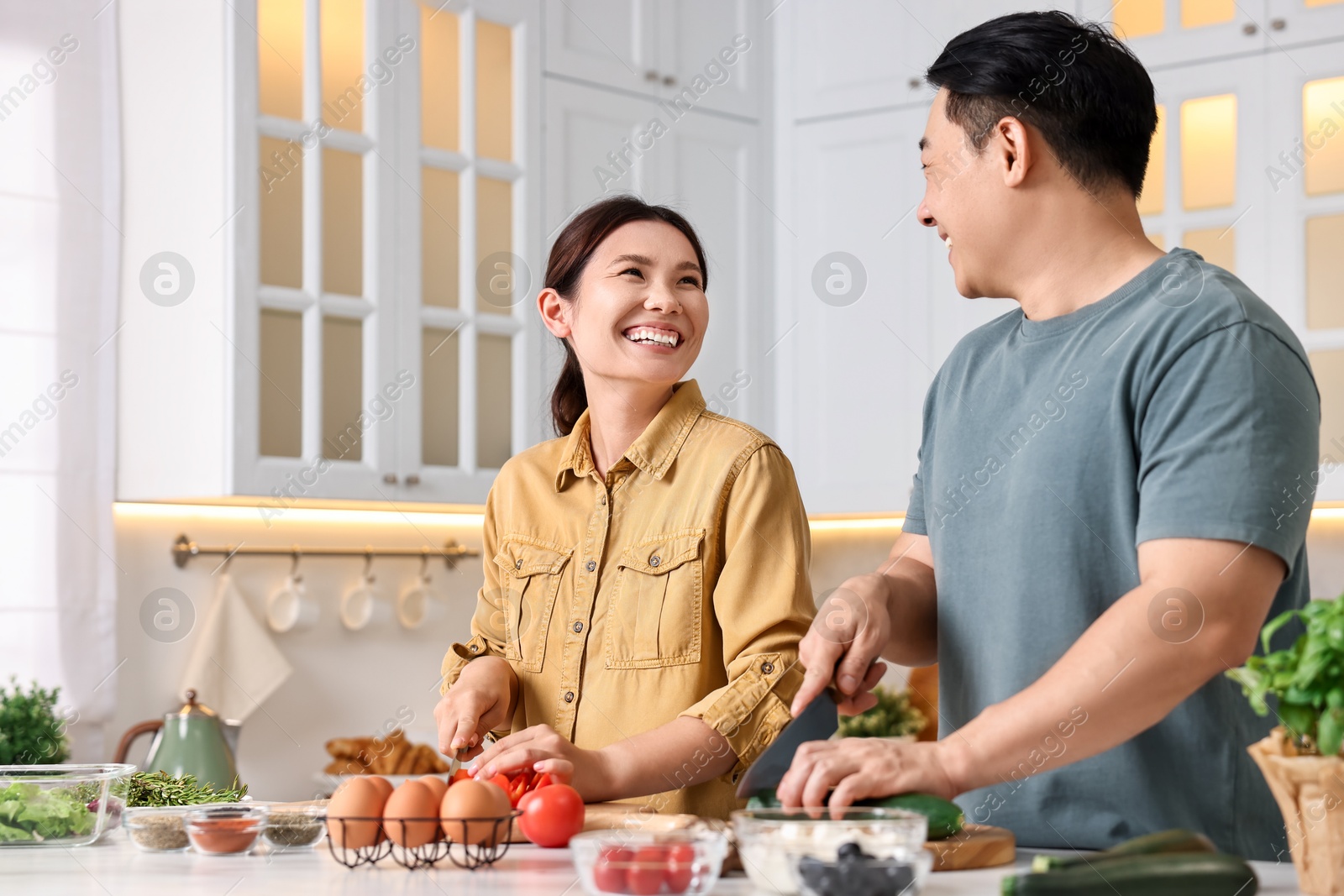 Photo of Happy lovely couple cooking together in kitchen