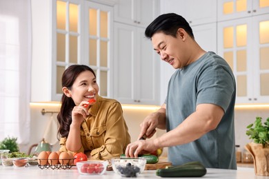 Happy lovely couple cooking together in kitchen