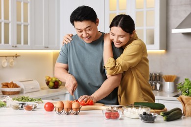 Happy lovely couple cooking together in kitchen