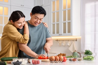 Photo of Happy lovely couple cooking together in kitchen