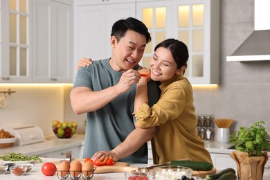 Photo of Happy lovely couple cooking together in kitchen