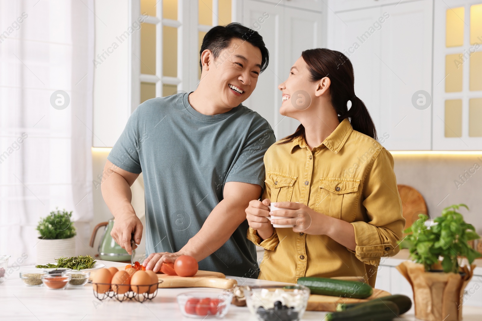 Photo of Happy lovely couple cooking together in kitchen