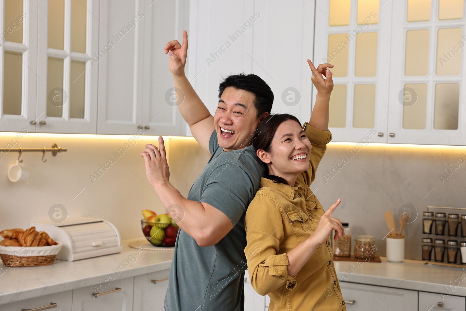 Photo of Happy lovely couple dancing together in kitchen