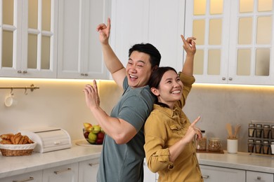 Happy lovely couple dancing together in kitchen