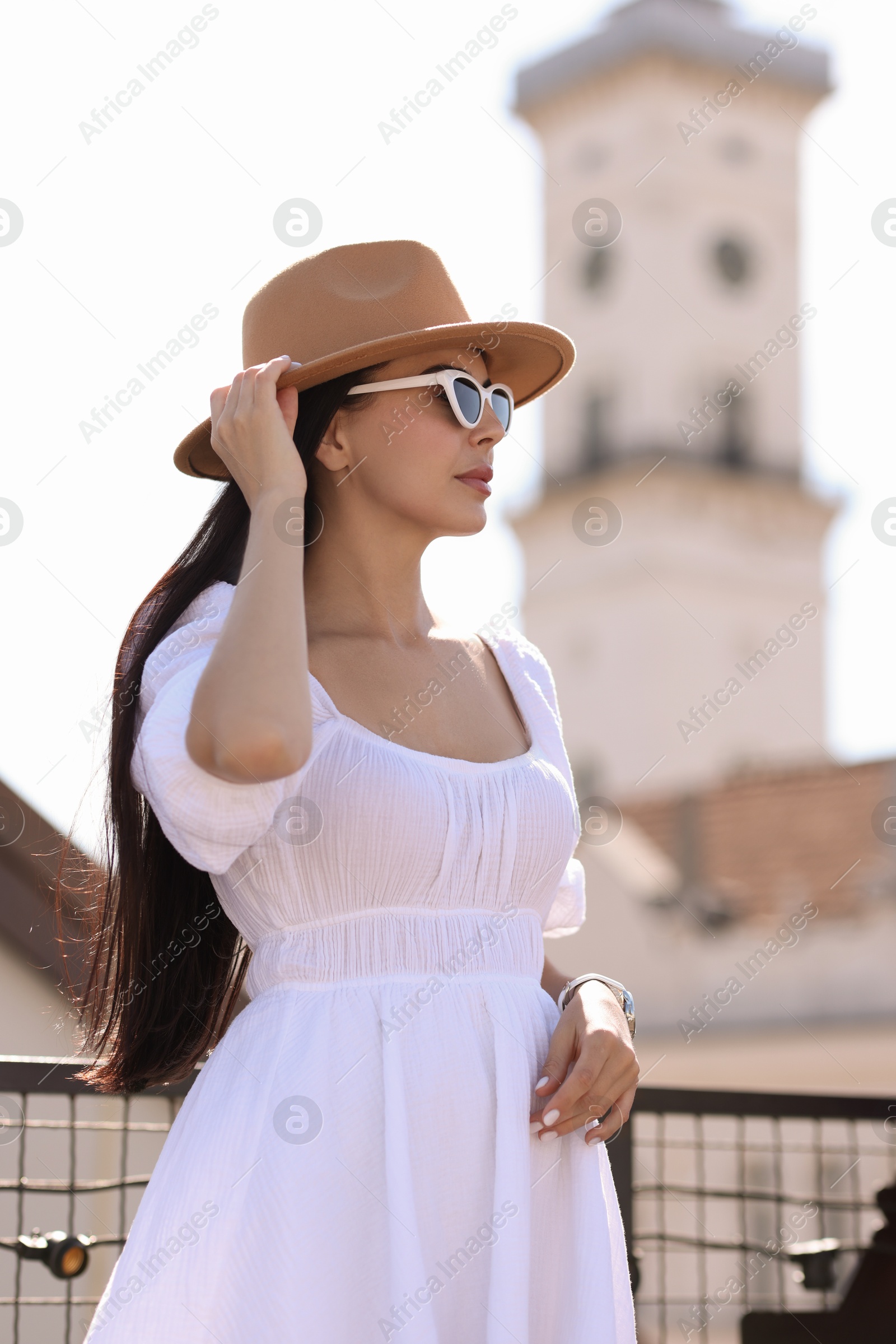 Photo of Young woman in stylish hat and sunglasses on city street