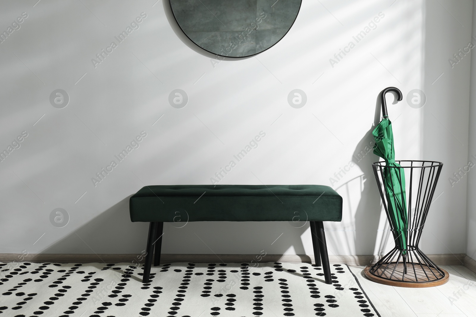 Photo of Green umbrella in stand near light wall