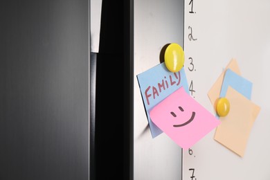 Photo of Magnetic board with to do list and notes on refrigerator, closeup