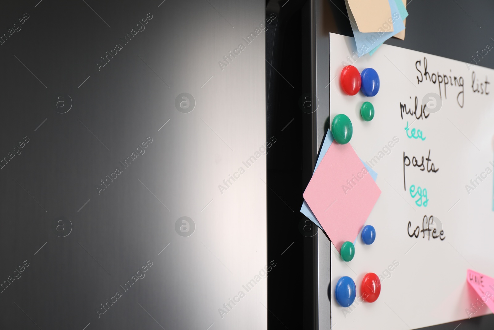 Photo of Magnetic board with shopping list and notes on refrigerator