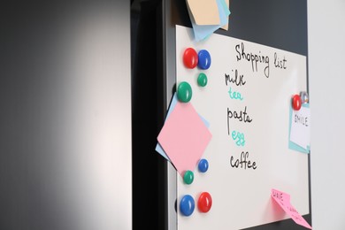 Photo of Magnetic board with shopping list and notes on refrigerator