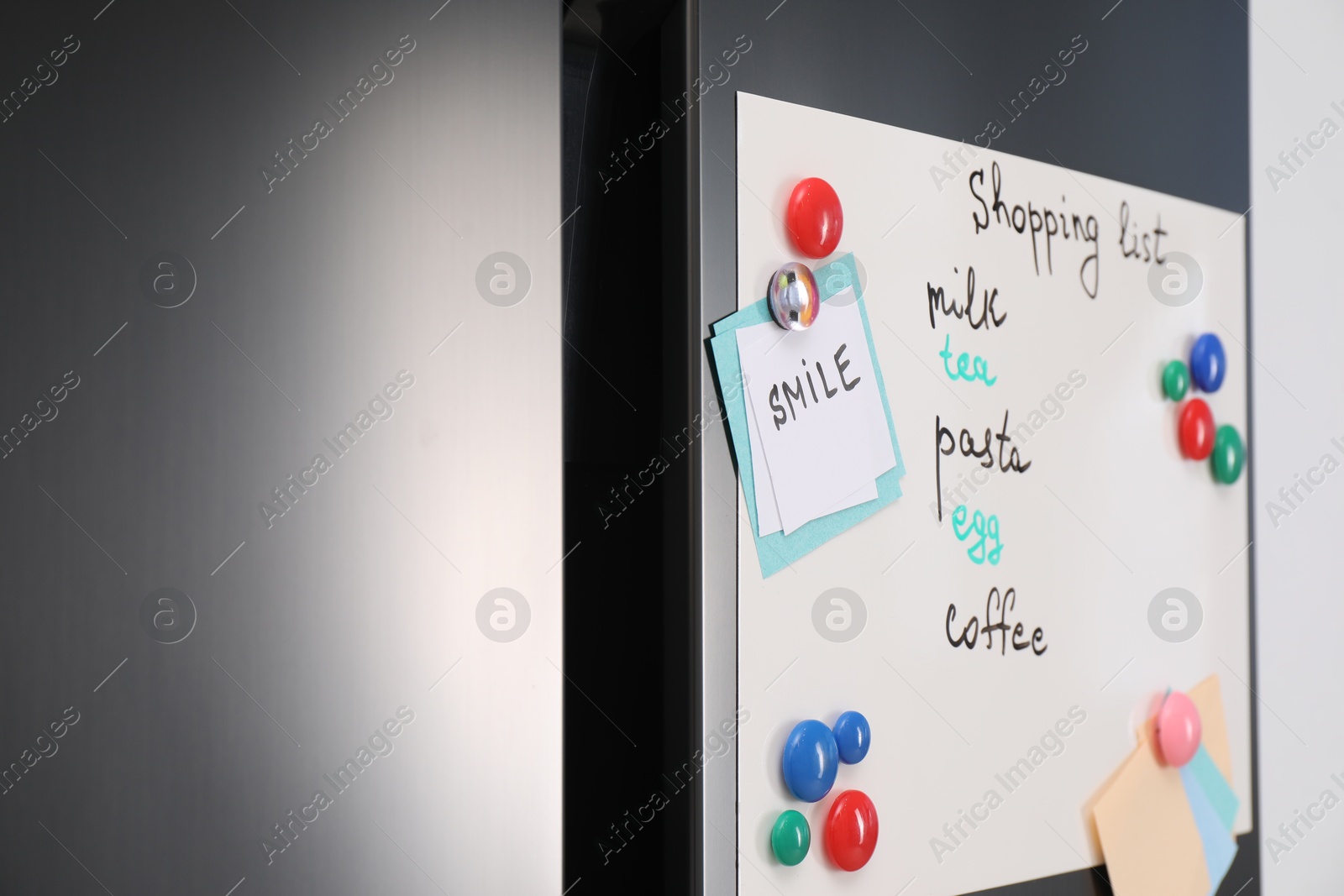 Photo of Magnetic board with shopping list and notes on refrigerator