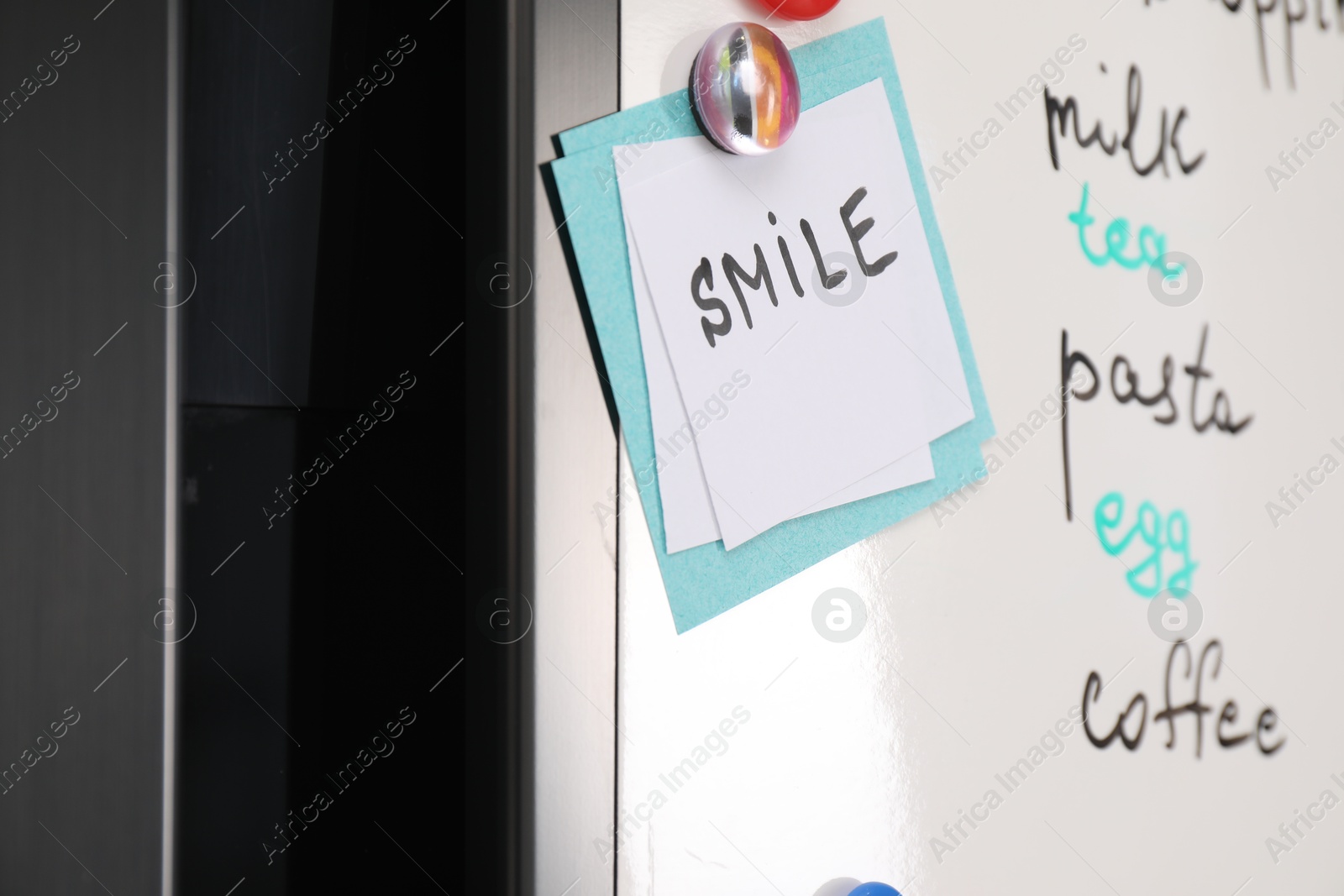 Photo of Magnetic board with shopping list and notes on refrigerator, closeup