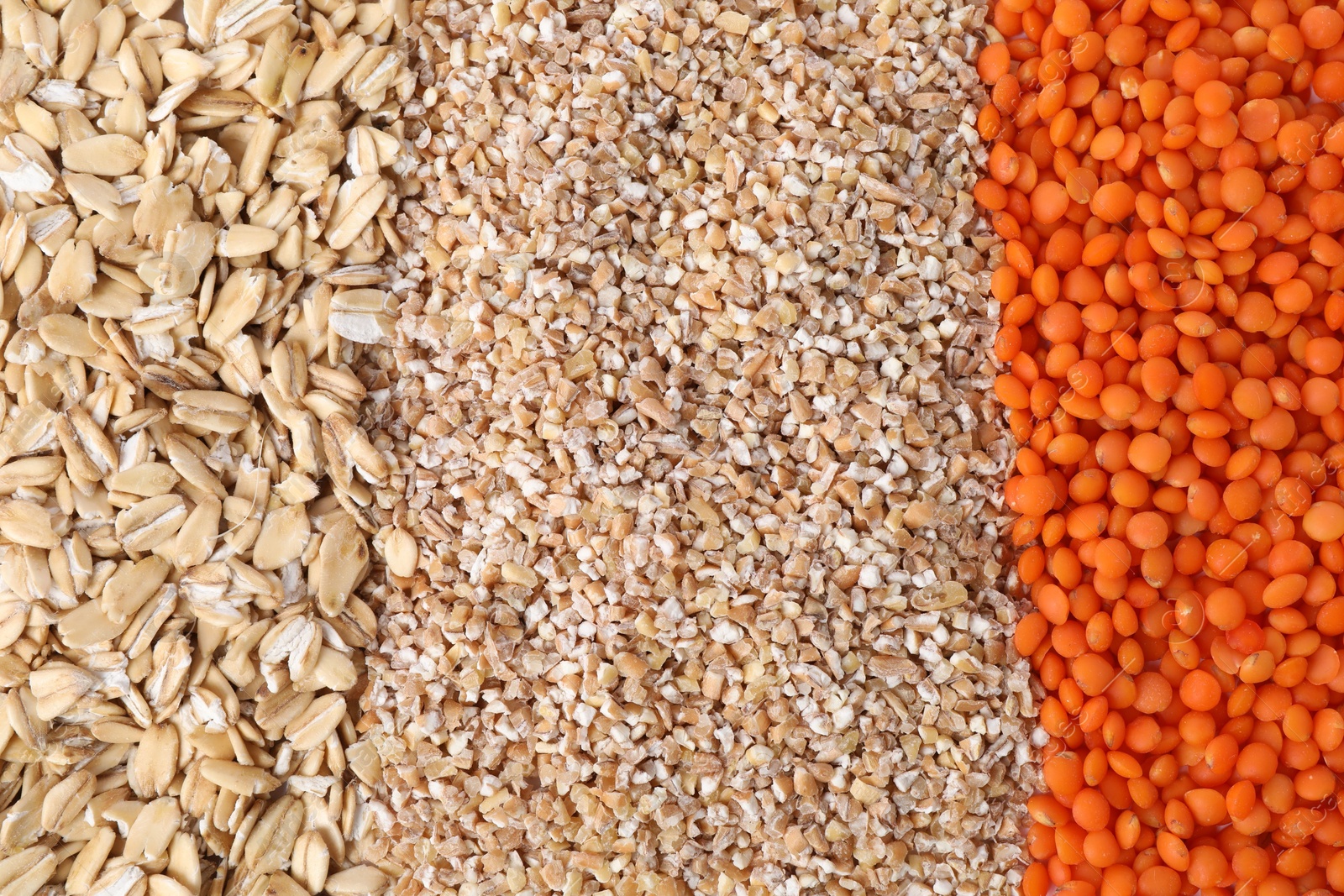 Photo of Red lentils, wheat groats and oat flakes as background, top view