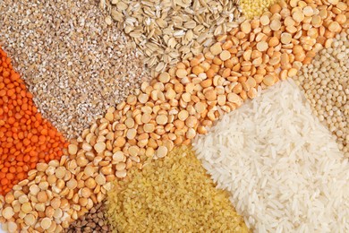 Different types of cereals and legumes as background, top view