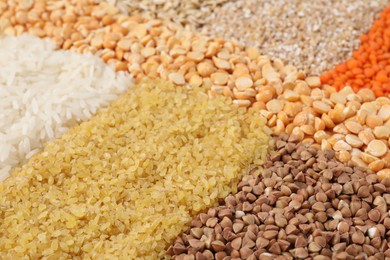 Photo of Different types of cereals and lentils as background, closeup